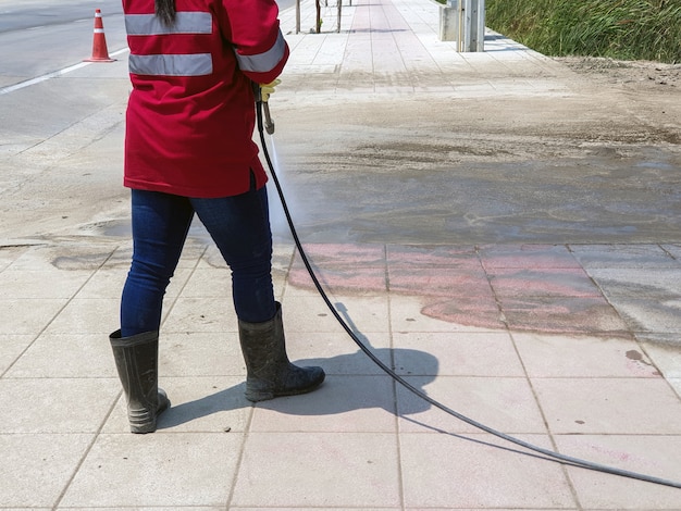 Foto arbeider die concrete blokvloer schoonmaken door waterstraal onder hoge druk