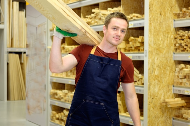 Foto arbeider in bouwopslag of pakhuis houten sectie op het werk