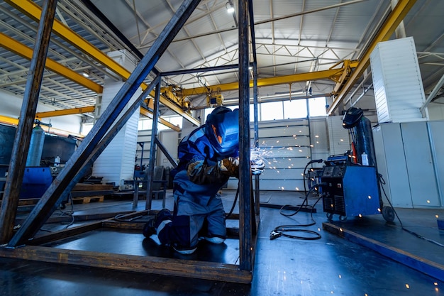 Arbeider in helmlassen Industriële lasser op werkplaats