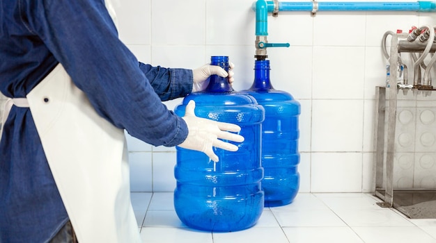 Arbeider in werkkleding aan het werk produceert drinkwater in een schoon drinkwaterfabriek