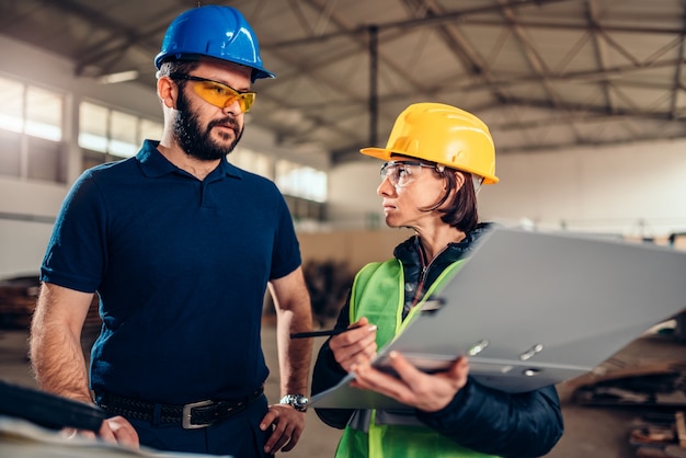 Arbeidsveiligheidsinspecteur die een rapport schrijven bij industriële fabriek