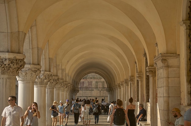 Arcades of Piazza San Marco in Venice with the underlying passage full of tourists visiting the city.