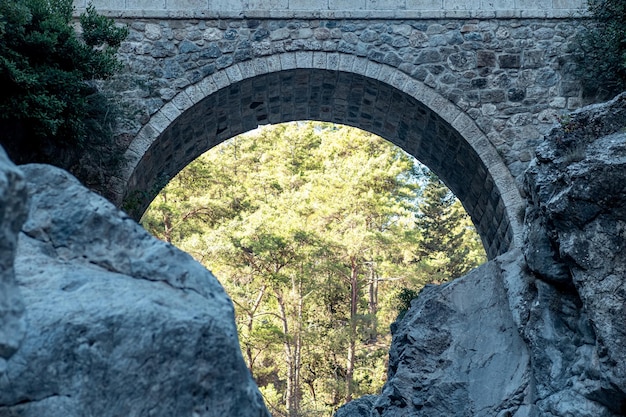 Arch of ancient Roman bridge over a mountain river gorge in the Kesme Bogazi canyon, Turkey