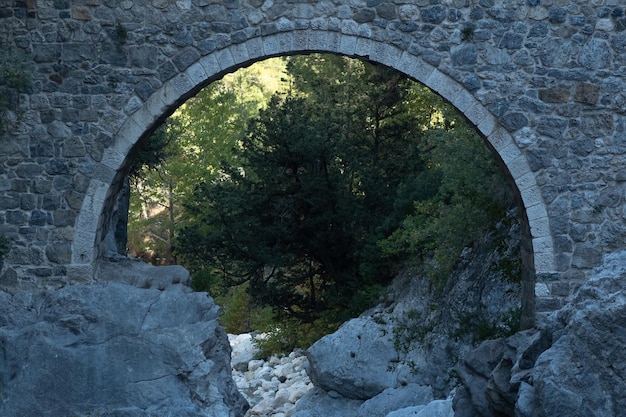 Photo arch of ancient roman bridge over a mountain river gorge in the kesme bogazi canyon, turkey