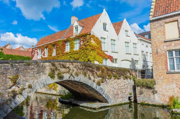 Arch bridge over canal amidst buildings against sky