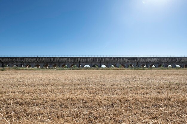 Foto ponte ad arco sul campo contro un cielo blu limpido