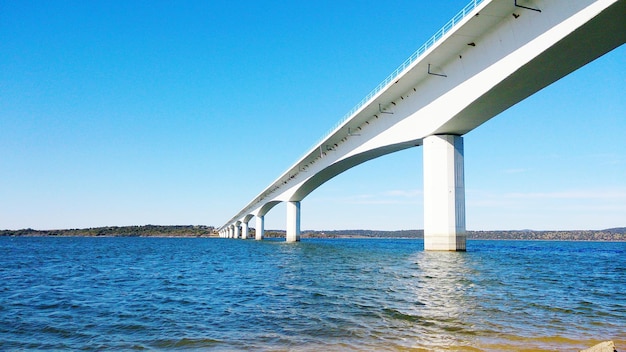 写真 空に照らされた湖の上のアーチ橋