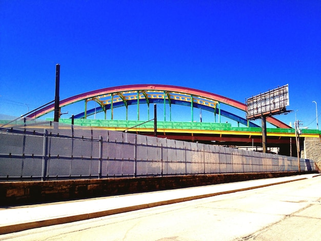 Photo arch bridge painted in rainbow color under clear sky