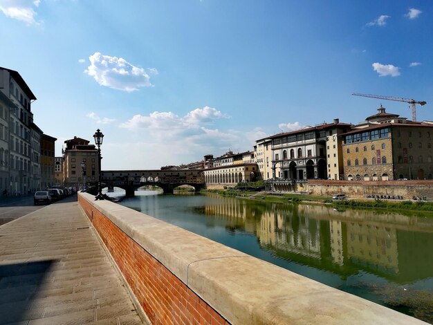 Arch bridge over river against buildings in the city of florence