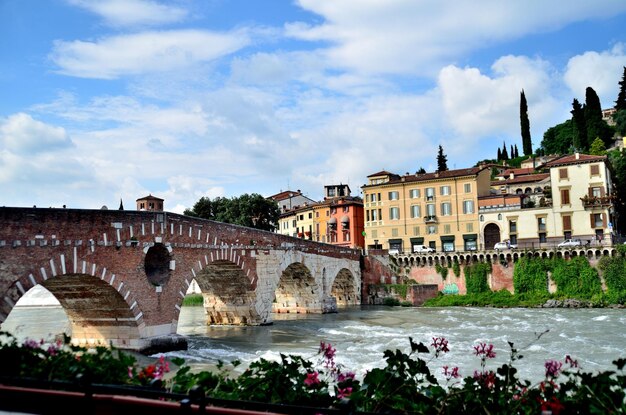 Arch bridge over river against buildings in city