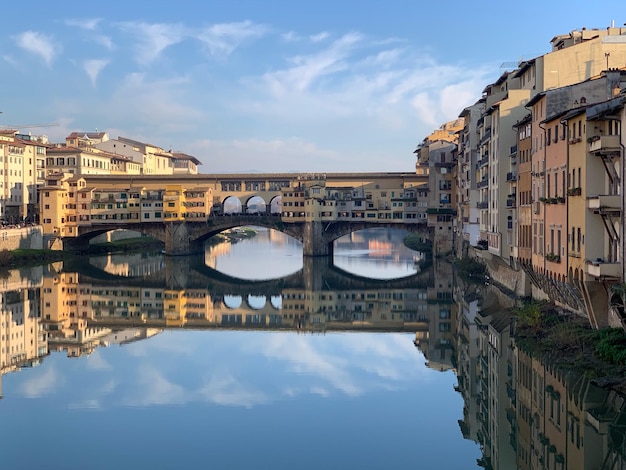 Foto ponte ad arco sul fiume contro gli edifici della città