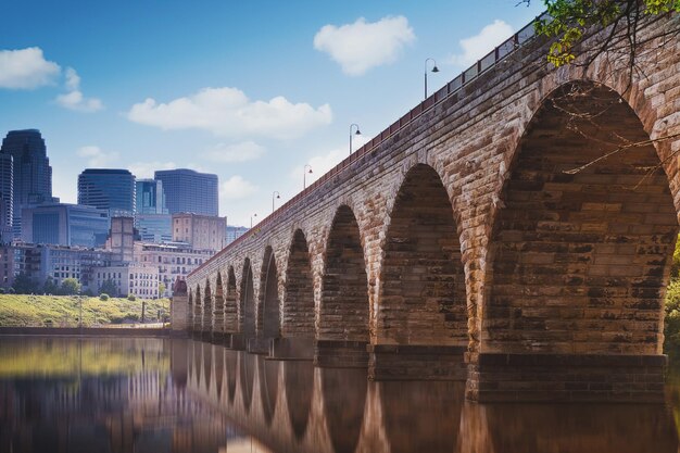 Photo arch bridge over river against buildings