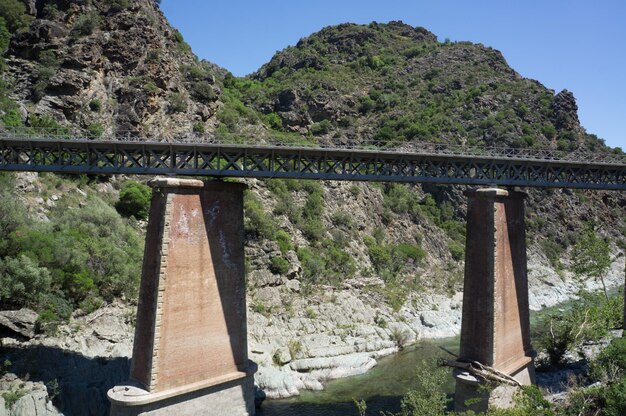 Arch bridge over river against mountain at corsica