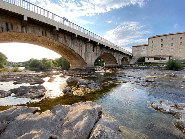 Arch bridge over river against sky