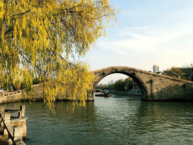 Arch bridge over river against sky