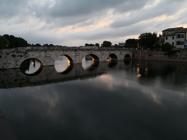 天空を背景に川を横断するアーチ橋