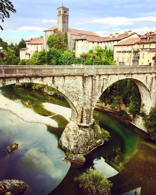 Arch bridge over river against sky