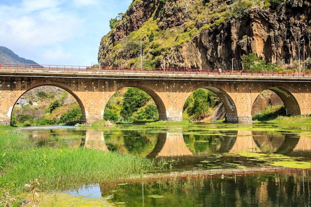 Arch bridge over river against sky