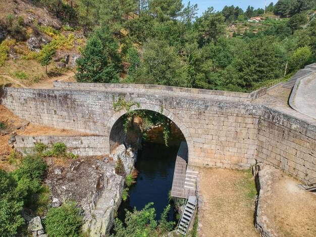 Photo arch bridge over river against trees