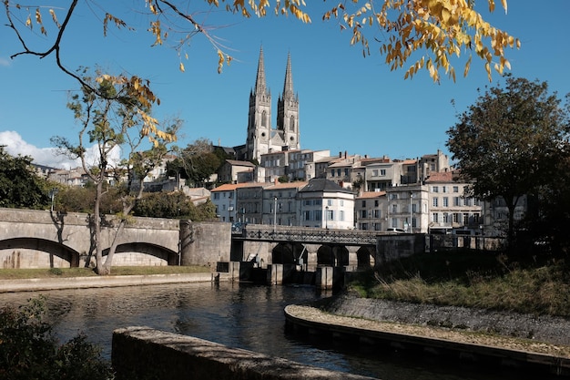 Arch bridge over river by buildings against clear sky