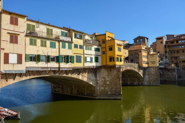 Foto ponte ad arco sul fiume da edifici contro il cielo in città