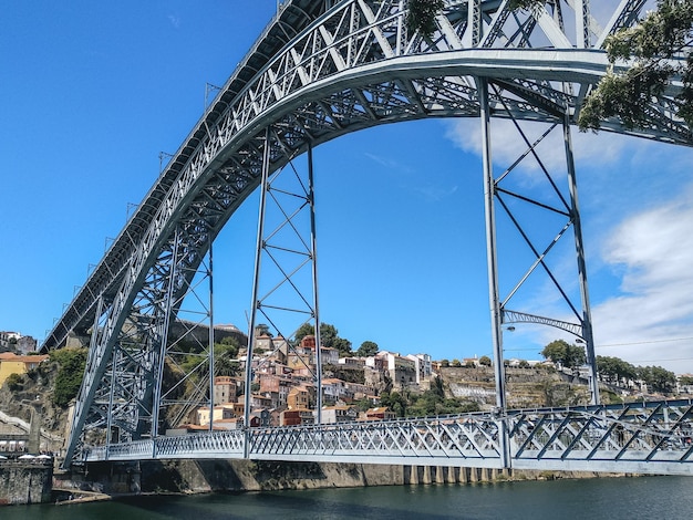 Foto ponte ad arco sul fiume in città contro il cielo blu