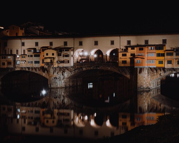 Foto ponte ad arco sul fiume in città contro il cielo di notte