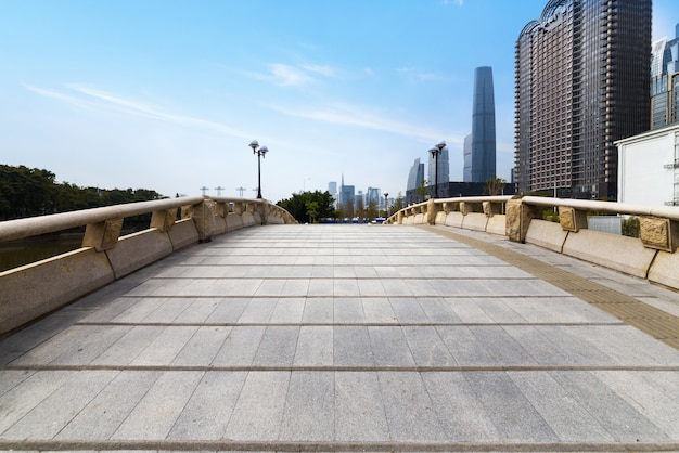 The arch bridge and skyscraper in the park are in Guangzhou, China.