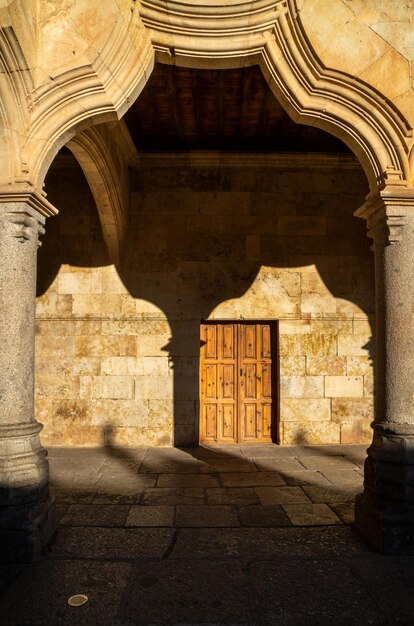 Photo arch and column of the cloister of the university of salamanca with its shadow on the wall