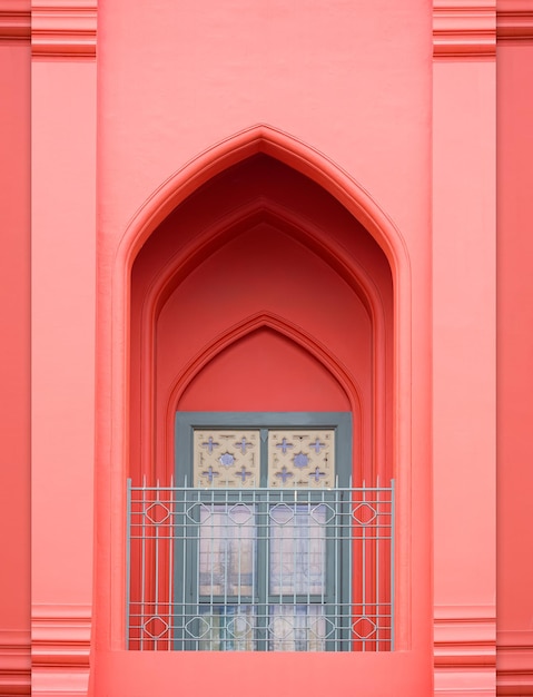 Arch door in Moroccan style with wooden window on balcony of vintage old rose building