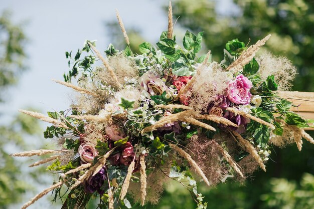 写真 花と緑で飾られた結婚式のアーチ