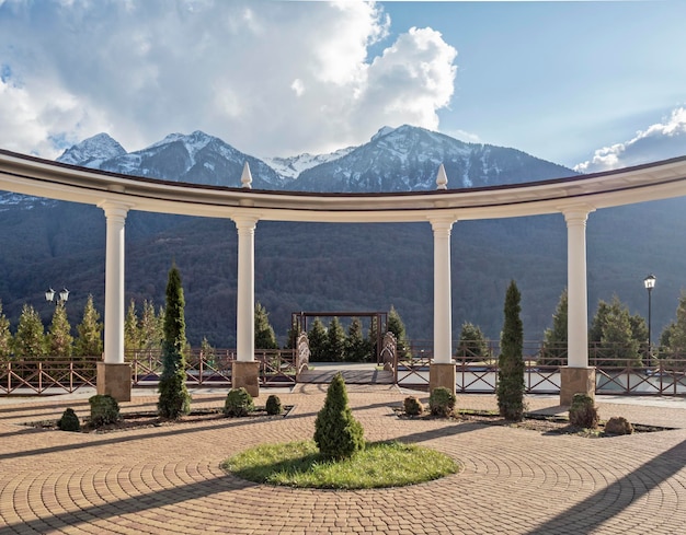 Arch with columns in park at mountains background