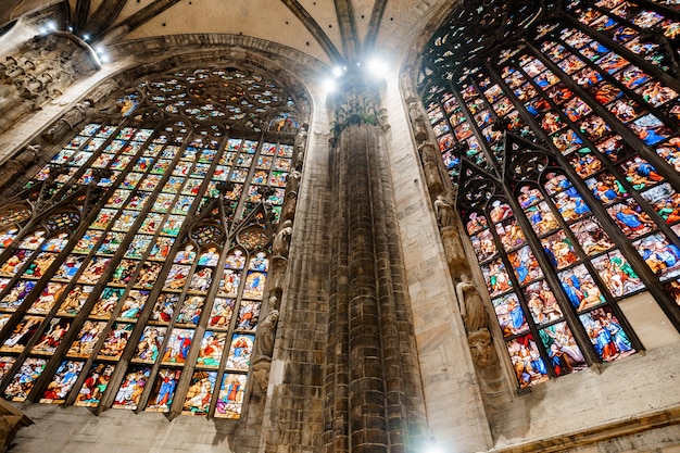 Arched vault of colored stained glass windows between the columns in the duomo italy milan