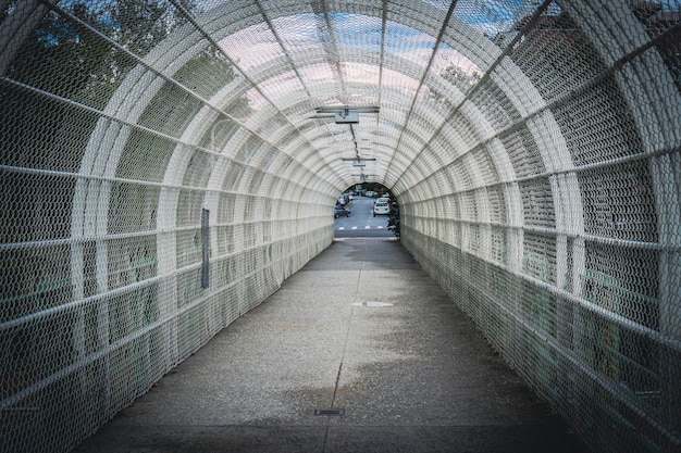 Photo arched walkway with metal wire mesh over highway for pedestrians