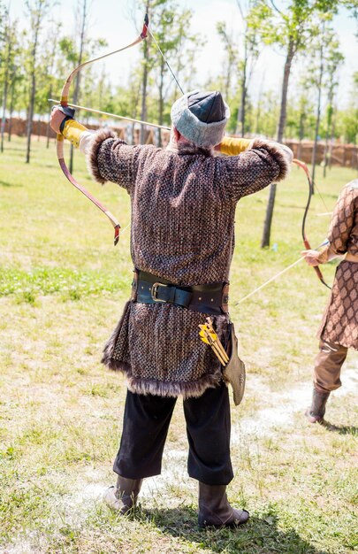 Foto arciere in abiti tradizionali che scocca una freccia