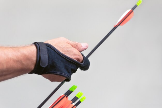 Archery. Archer exercise with the bow. Sport, recreation concept. Sportsman is preparing the arrow for the shot.