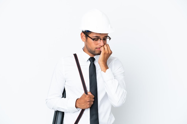 Architect brazilian man with helmet and holding blueprints having doubts