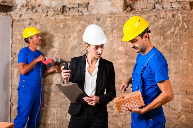 Architect and builder on construction site discussing