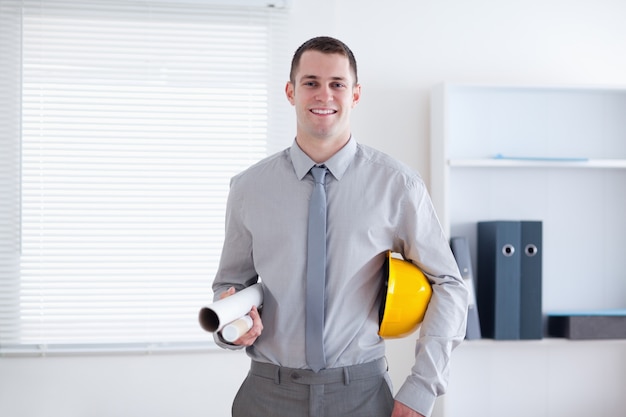 Architect carrying helm and plans