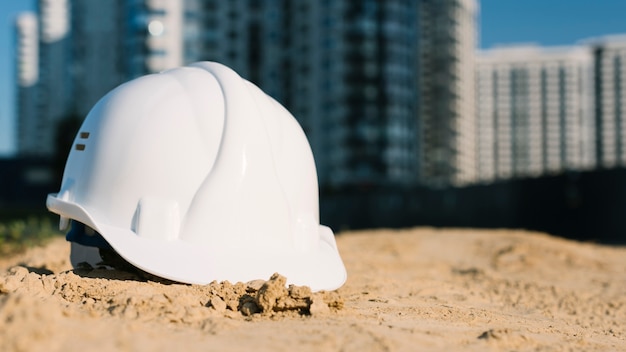 Architect concept with safety helmet on sand