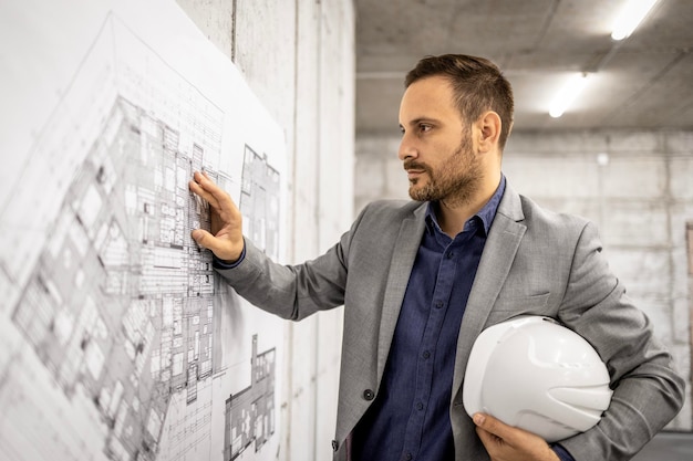 Photo architect or construction engineer looking at project plan and thinking