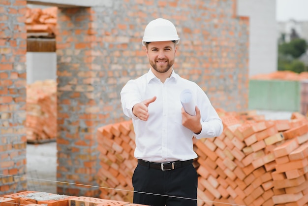 Architect at a construction site with blueprints