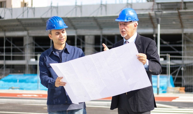 architect developers reviewing building plans at construction site