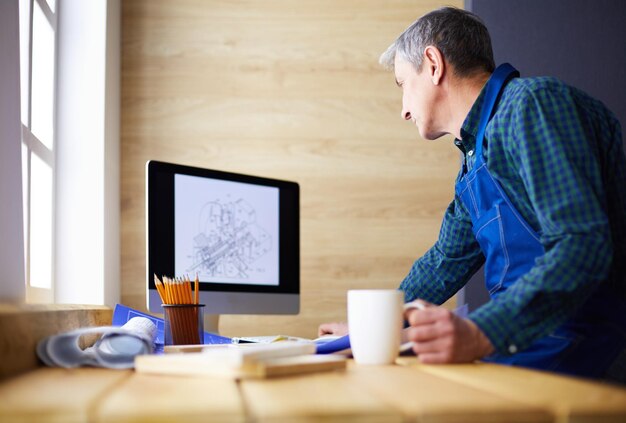 Architect die aan tekentafel in bureau werkt