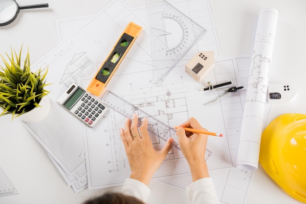 Architect drawing with ruler on house plan blueprint paper for repair tools on table