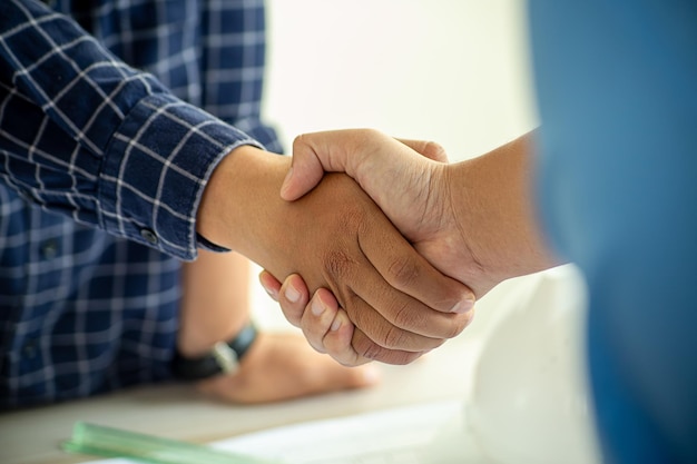 Architect en ingenieur bouwvakkers die elkaar de hand schudden na een succesvolle samenwerking