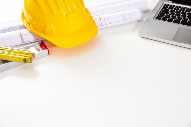 architect engineer office construction safety helmet building blueprint and laptop on white