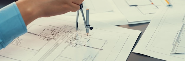 Architect or engineer working on building blueprint in office Insight