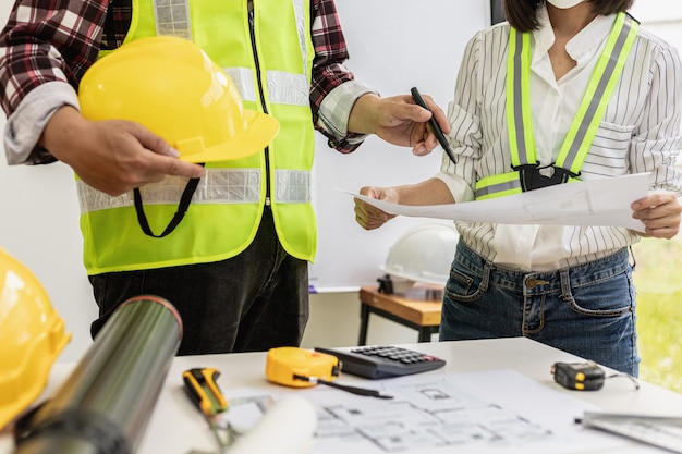 Architect engineers are standing by to look at the blueprints\
of the designed houses, they meet together to plan the construction\
and modify some of the designs. design and interior design\
ideas.