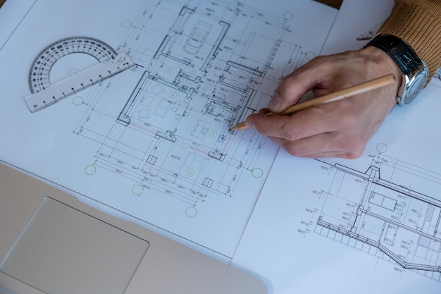 建築家の手で設計図を描き,家の設計をスケッチし,プロジェクトに取り組んで,オフィスで建築の建設をしています.